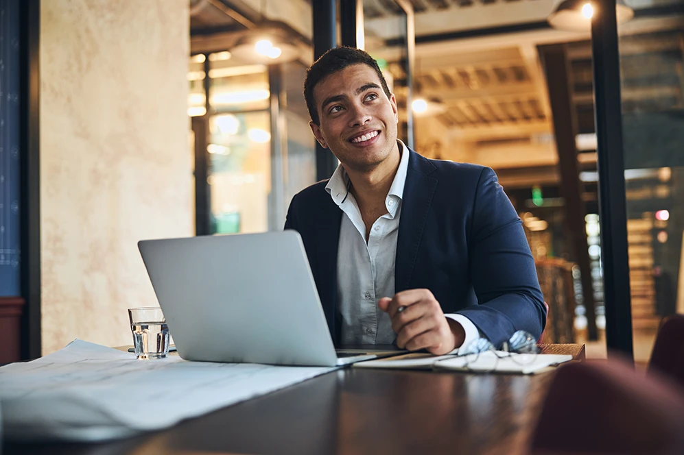 Handsome business man sitting at desk in front of laptop