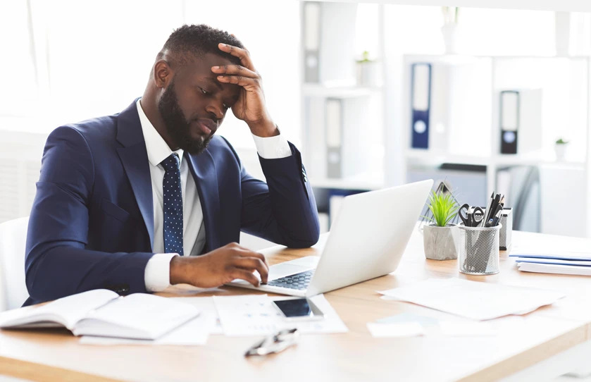 African american struggling in front of  laptop